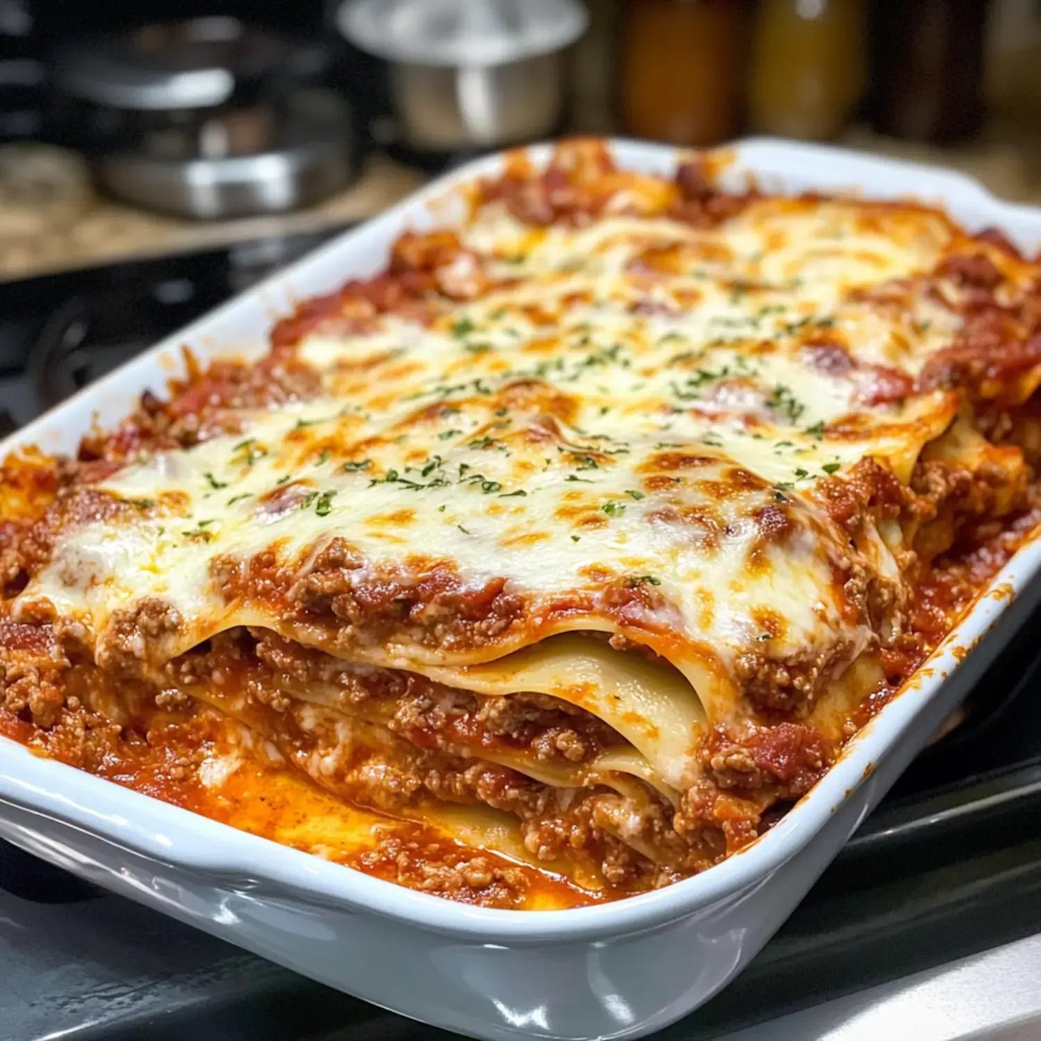 Eine Nahaufnahme einer frisch gebackenen Lasagne mit Schichten aus Pasta, Fleischsauce und geschmolzenem Käse, garniert mit Kräutern.