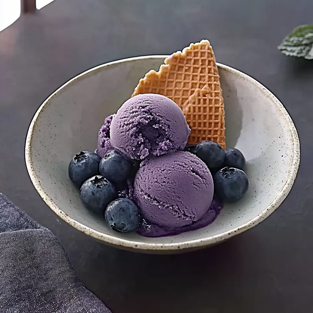 Ein Glas mit Eiscreme und Waffeln.