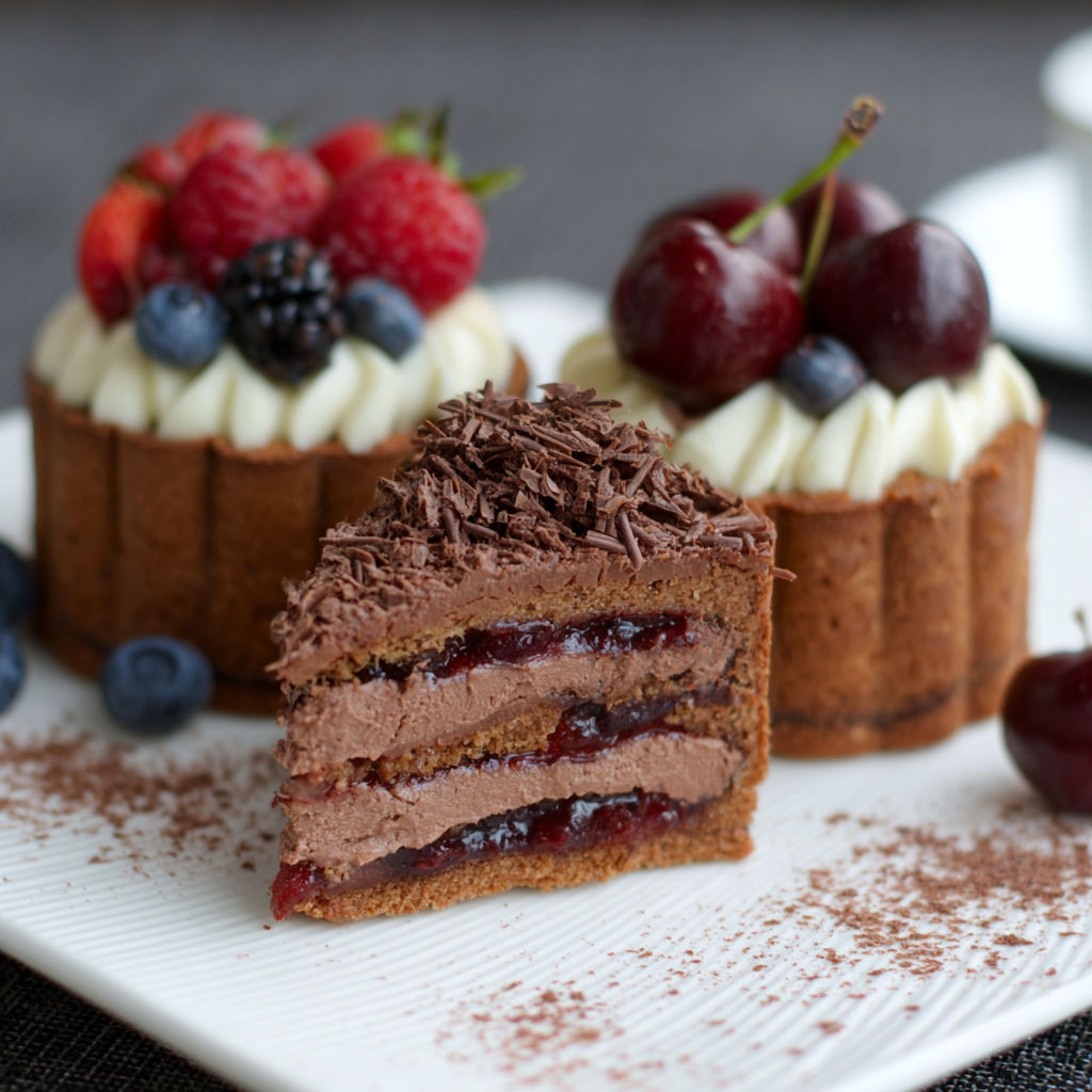 A slice of cake with chocolate and fruit toppings.