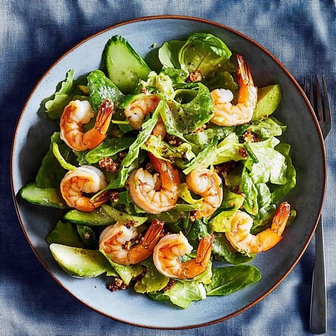 Ein Schmelztisch mit einer Salatgarnitur, die aus Zucchini, Shrimp, Linsen und Zwiebeln besteht.
