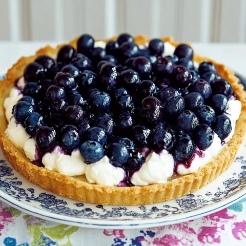 Ein Plate mit einer Tarte, die mit Blaubeeren und Vanilleeis zubereitet wurde.