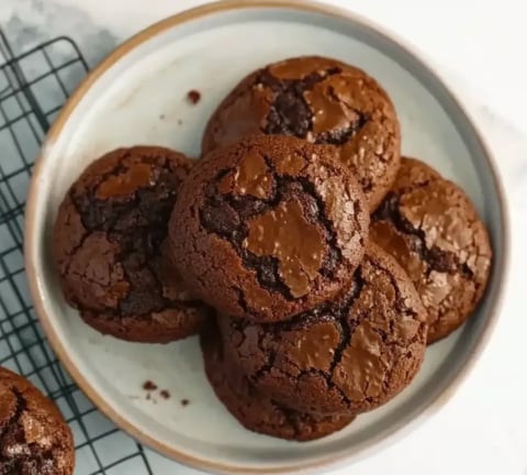 Ein weißer Teller mit einer Schüssel voller Chocolate-Cookies.