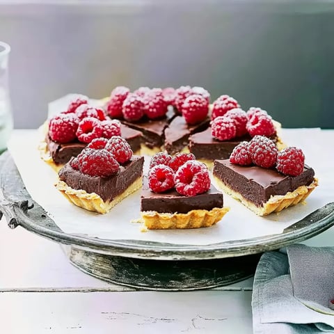 Eine Tasse mit Raspberry-Schokolade-Kuchen auf einem Teller.