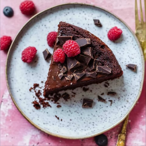 Eine Schokoladenkuche mit Raspberry-Fruchtgarnitur auf einem Plate.