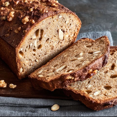 A slice of bread with nuts on top.