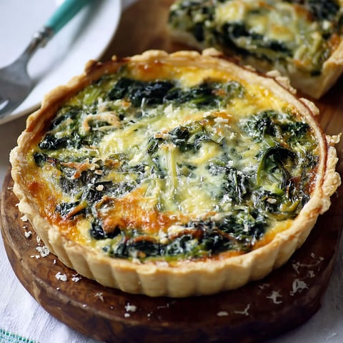 A spinach quiche on a wooden board.