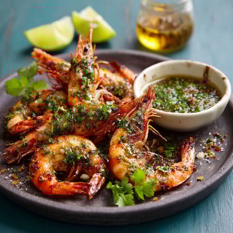 A plate of shrimp with a dipping sauce.