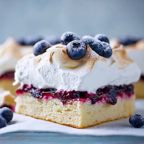 A slice of cake with blueberries on top.