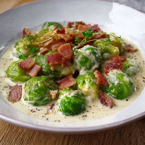 A plate of food with bacon and cream sauce.