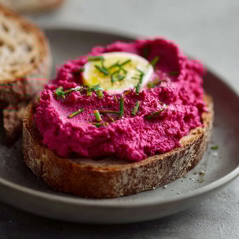 A plate of food with a red spread on a piece of bread.