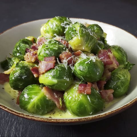 A plate of greens with bacon on top.
