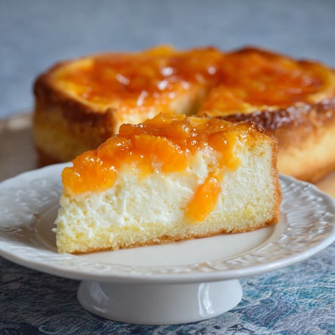 A slice of Mandarinen Schmand Kuchen on a plate.