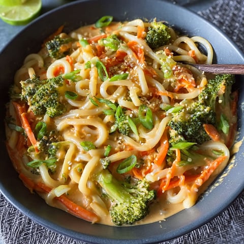 A bowl of noodles with vegetables and sauce.